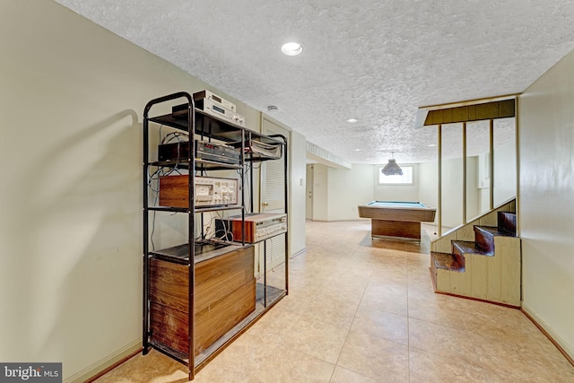 hall with recessed lighting, baseboards, a textured ceiling, and tile patterned floors