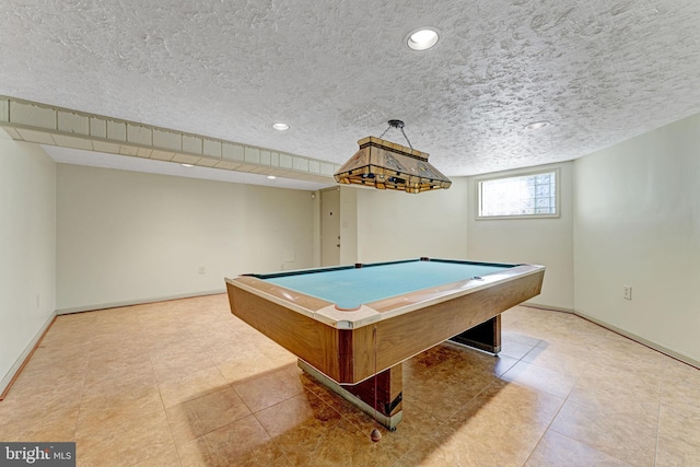 game room featuring light tile patterned flooring, a textured ceiling, and baseboards