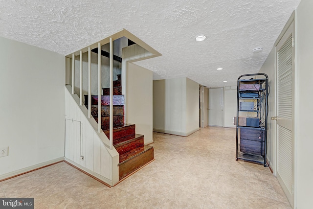 interior space featuring recessed lighting, baseboards, a textured ceiling, and stairs