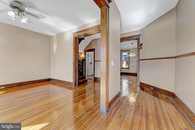 unfurnished room featuring baseboards, wood-type flooring, and ceiling fan