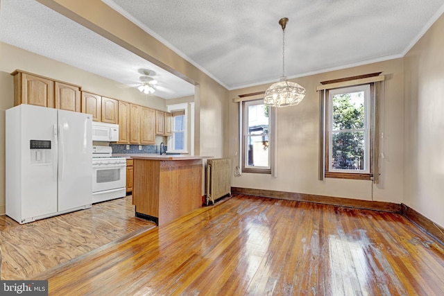 kitchen featuring light wood-type flooring, white appliances, radiator, a peninsula, and baseboards