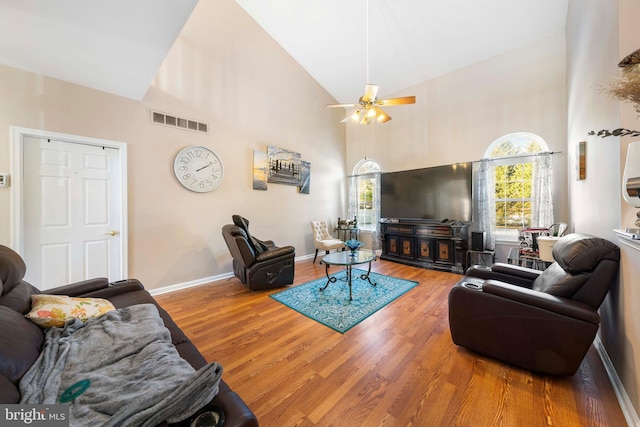 living room featuring hardwood / wood-style flooring, high vaulted ceiling, and ceiling fan