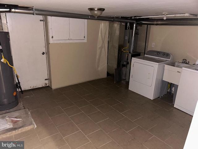 clothes washing area featuring water heater and washer / clothes dryer