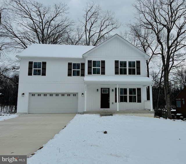 view of front of home with a garage, covered porch, and driveway