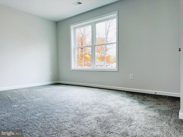 empty room featuring baseboards, visible vents, and carpet floors