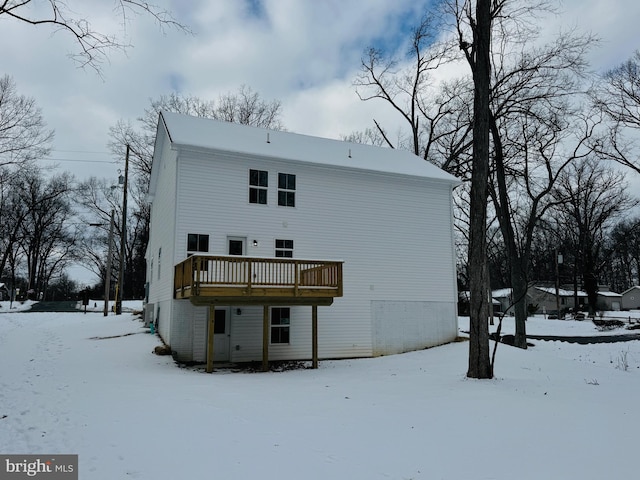 snow covered house with a deck