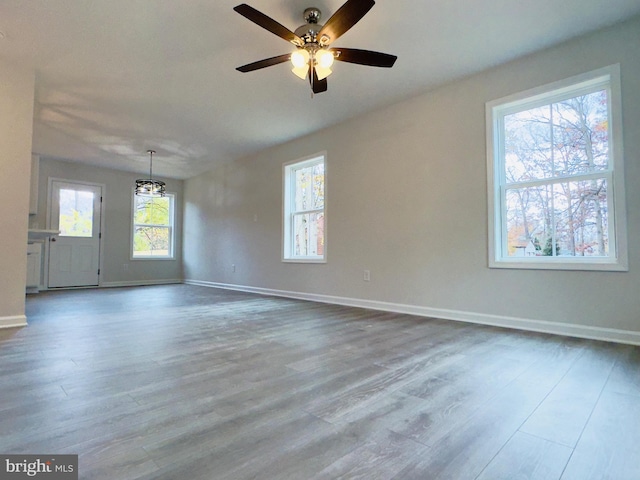 spare room featuring baseboards, ceiling fan, and wood finished floors