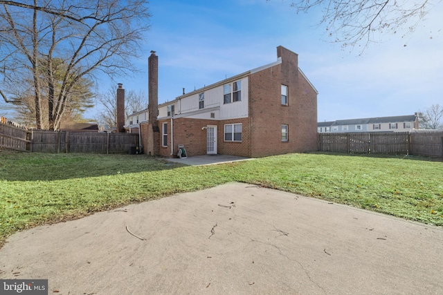 rear view of house with a lawn and a patio area