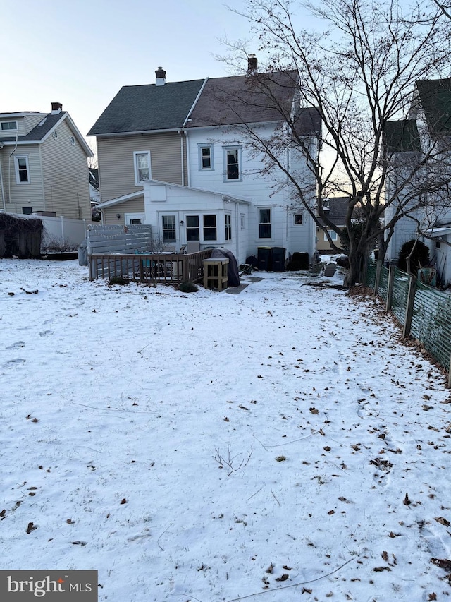 snow covered house featuring a deck