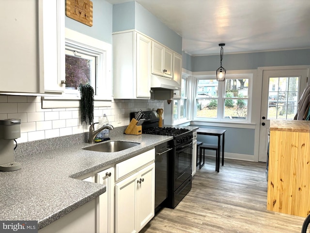 kitchen featuring backsplash, sink, black appliances, decorative light fixtures, and white cabinets