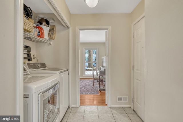 laundry area featuring independent washer and dryer and light tile patterned flooring