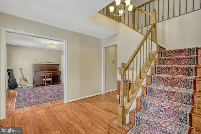 stairway featuring wood-type flooring and a chandelier