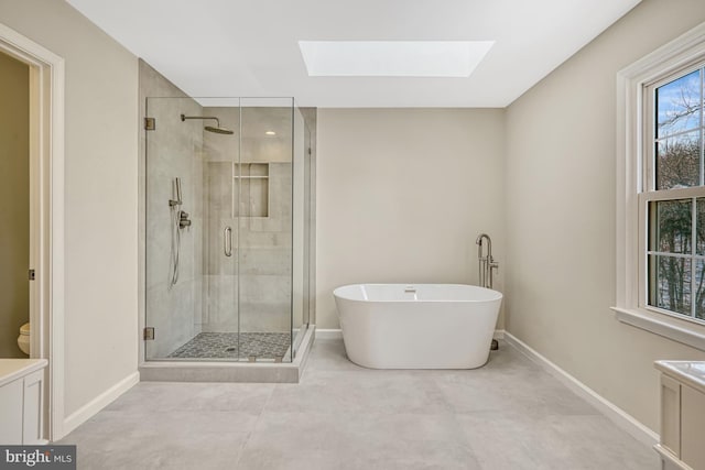 full bathroom with independent shower and bath, a wealth of natural light, a skylight, and vanity