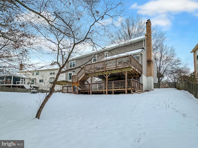 snow covered rear of property featuring a wooden deck