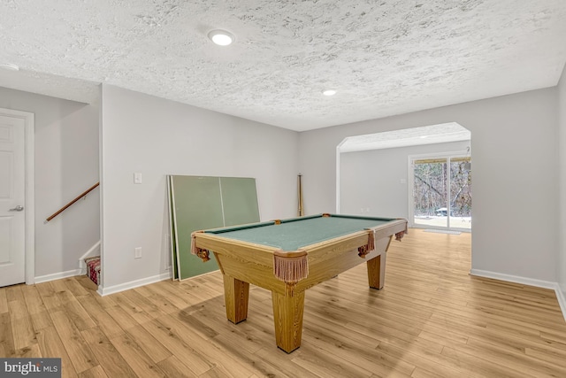 recreation room with a textured ceiling, billiards, and light wood-type flooring