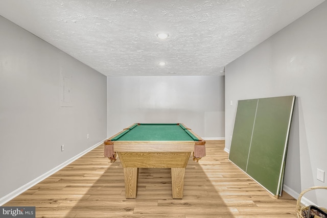 game room with billiards, wood-type flooring, and a textured ceiling