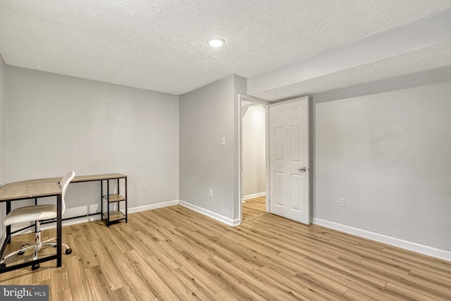 office with a textured ceiling and light hardwood / wood-style flooring