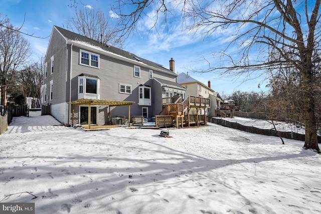 snow covered property with cooling unit and a wooden deck