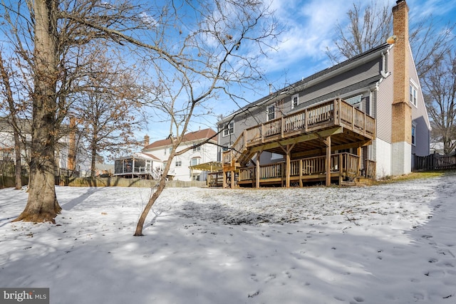 snow covered property with a wooden deck