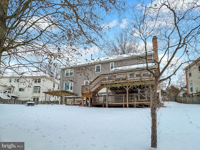 snow covered back of property featuring a wooden deck