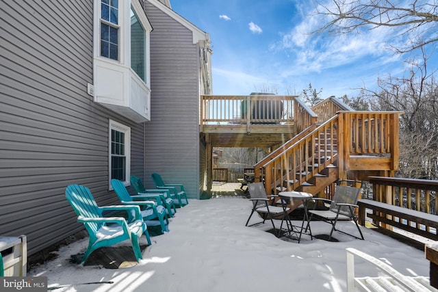 snow covered patio featuring a deck