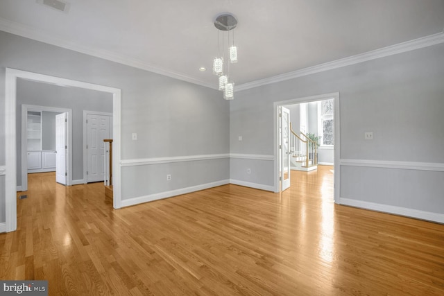 empty room featuring light hardwood / wood-style floors and crown molding