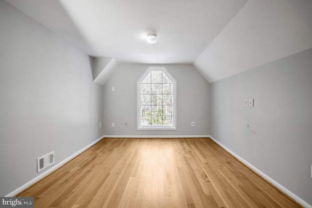 bonus room with lofted ceiling and light hardwood / wood-style floors