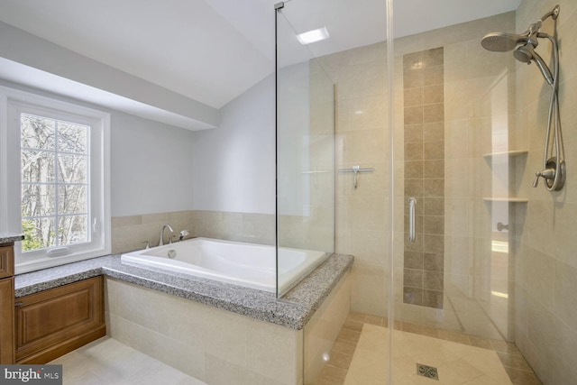 bathroom with vaulted ceiling, tile patterned floors, and independent shower and bath