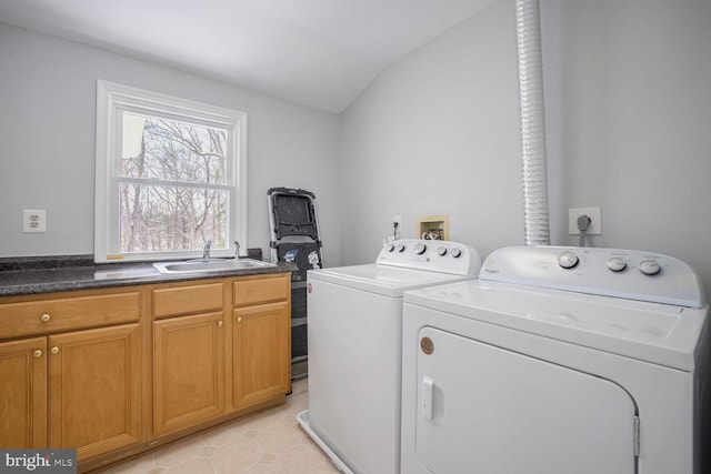 clothes washing area with sink, light tile patterned floors, cabinets, and independent washer and dryer