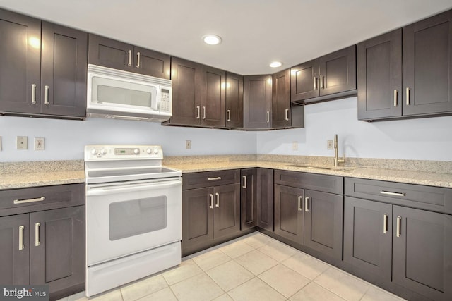 kitchen featuring white appliances, light tile patterned floors, sink, and dark brown cabinetry