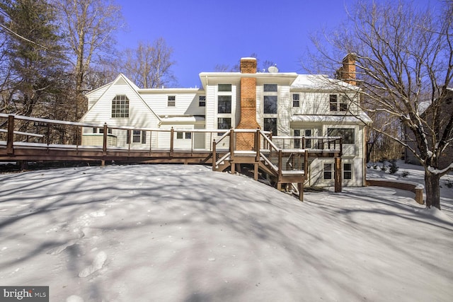 snow covered house with a deck