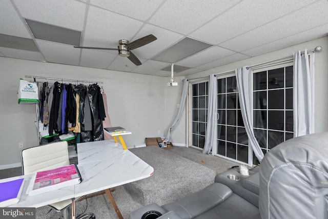 interior space featuring carpet, a drop ceiling, and ceiling fan