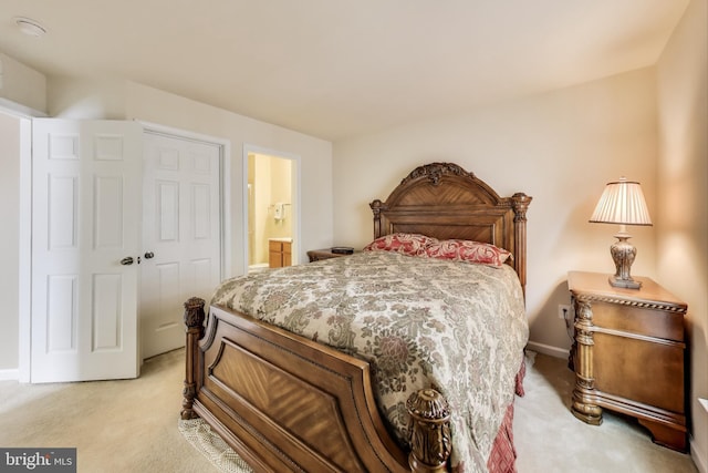 carpeted bedroom featuring a closet and ensuite bath