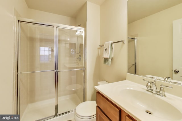 bathroom featuring toilet, walk in shower, and vanity