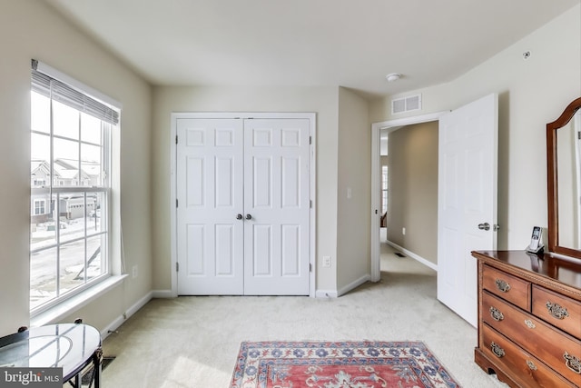 carpeted bedroom with multiple windows and a closet