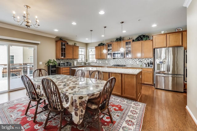 dining room with wood-type flooring, crown molding, and a notable chandelier