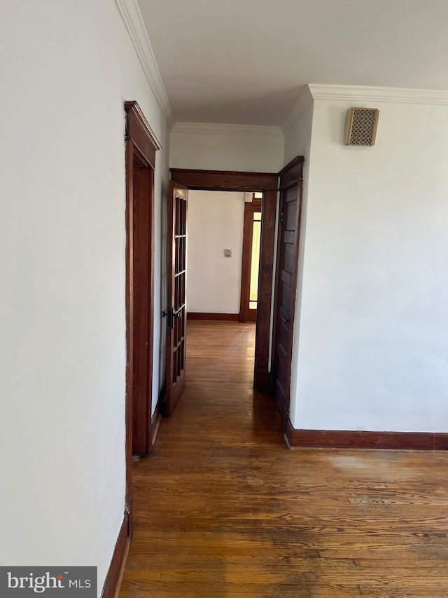 hallway with baseboards, dark wood-style flooring, and ornamental molding