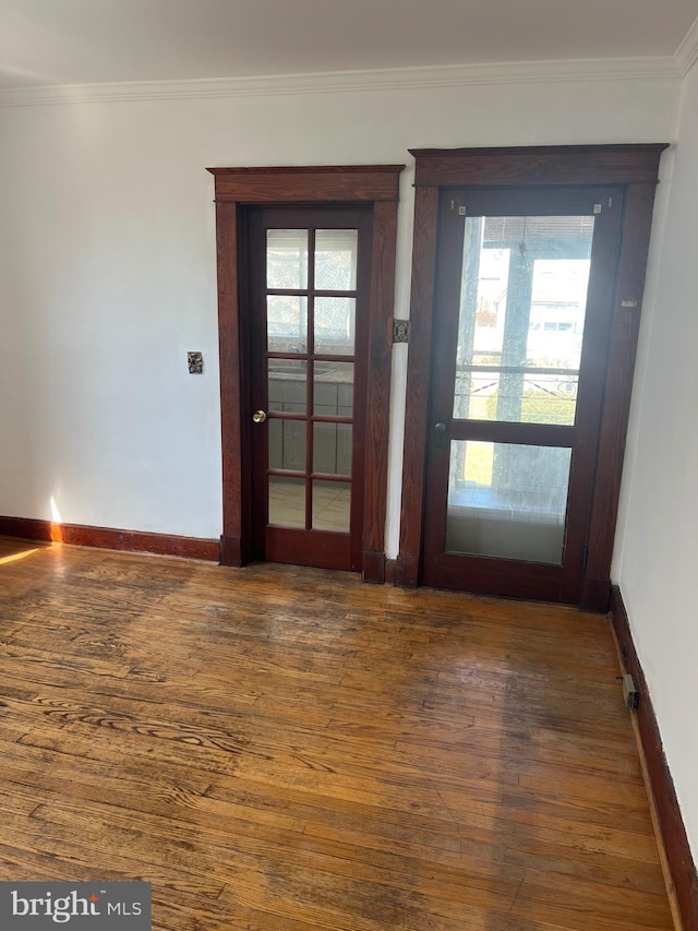 entryway with baseboards, wood-type flooring, and ornamental molding