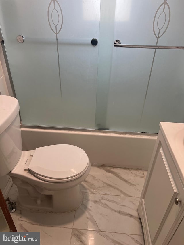 bathroom featuring enclosed tub / shower combo, toilet, marble finish floor, and vanity