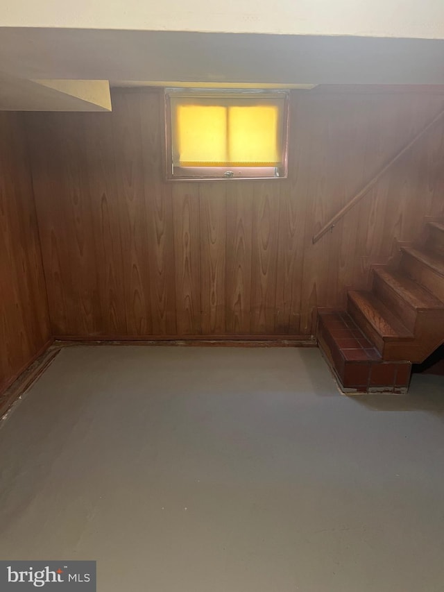 basement with stairway and wood walls