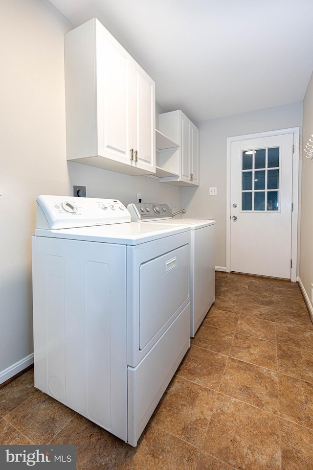 laundry area with washer and clothes dryer and cabinets