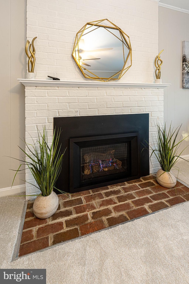 details featuring carpet, ornamental molding, and a brick fireplace