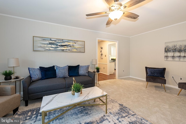 living room featuring ceiling fan, crown molding, and light carpet