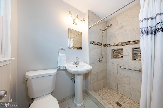 bathroom with sink, tile patterned flooring, curtained shower, and toilet