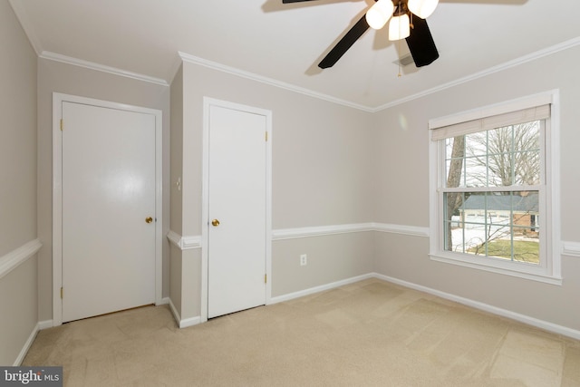 unfurnished bedroom featuring light carpet, ceiling fan, and ornamental molding