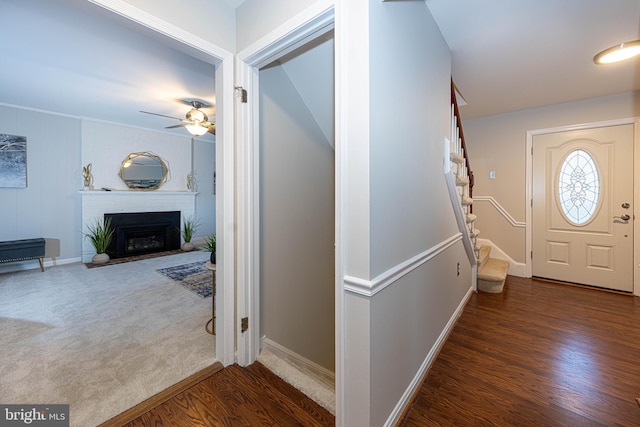 foyer featuring a fireplace, dark hardwood / wood-style floors, and ceiling fan