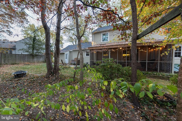 exterior space featuring a sunroom and a fire pit