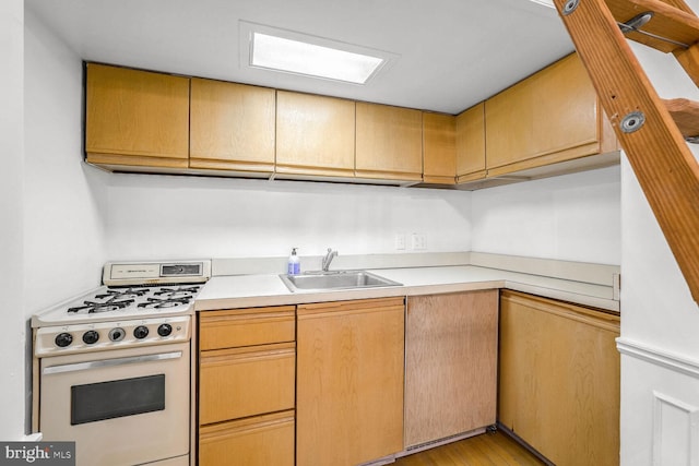 kitchen featuring white range, sink, and light hardwood / wood-style flooring