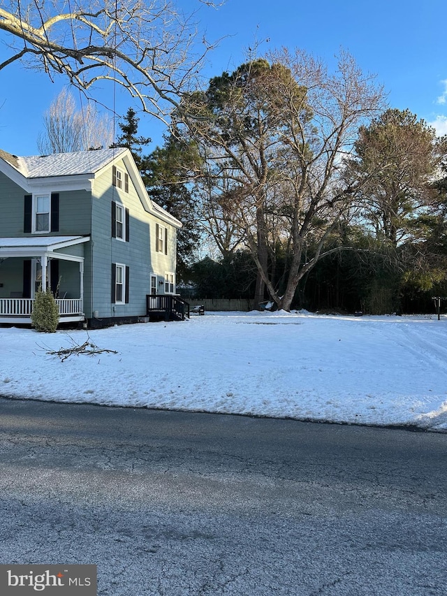 view of snowy exterior featuring covered porch