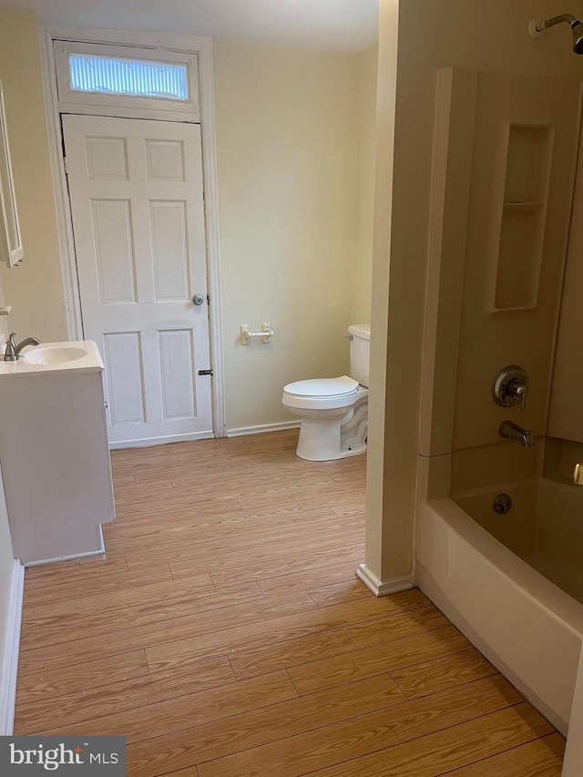 full bathroom with wood-type flooring, toilet, tub / shower combination, and vanity